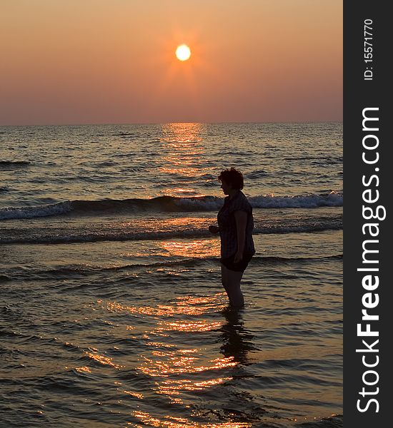 Teen girl looking for shells on beach at sunset. Teen girl looking for shells on beach at sunset