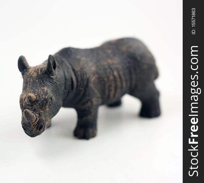 Miniature rhino with sharp focus on horn and body blurred on a white background. Miniature rhino with sharp focus on horn and body blurred on a white background.