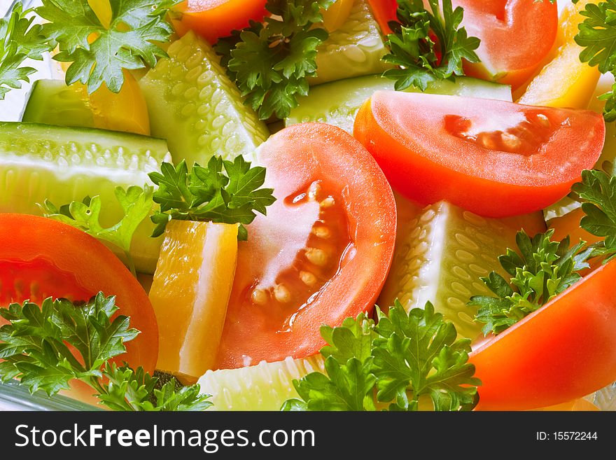 Fresh vegetables: tomatoes, cucumbers, a paprika and parsley in a plate