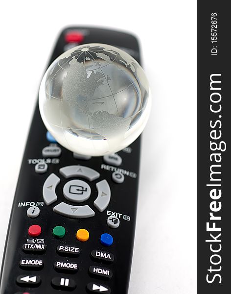 Studio shot of remote control and glass globe on it isolated on white background