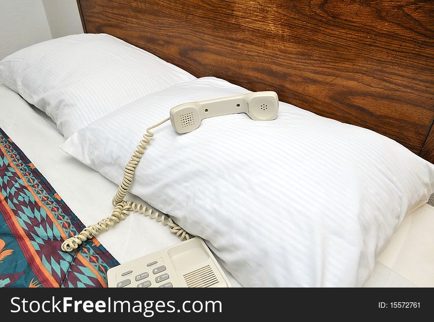 Closeup of telephone on bed pillow. For tourism, travel and backpacking concepts.