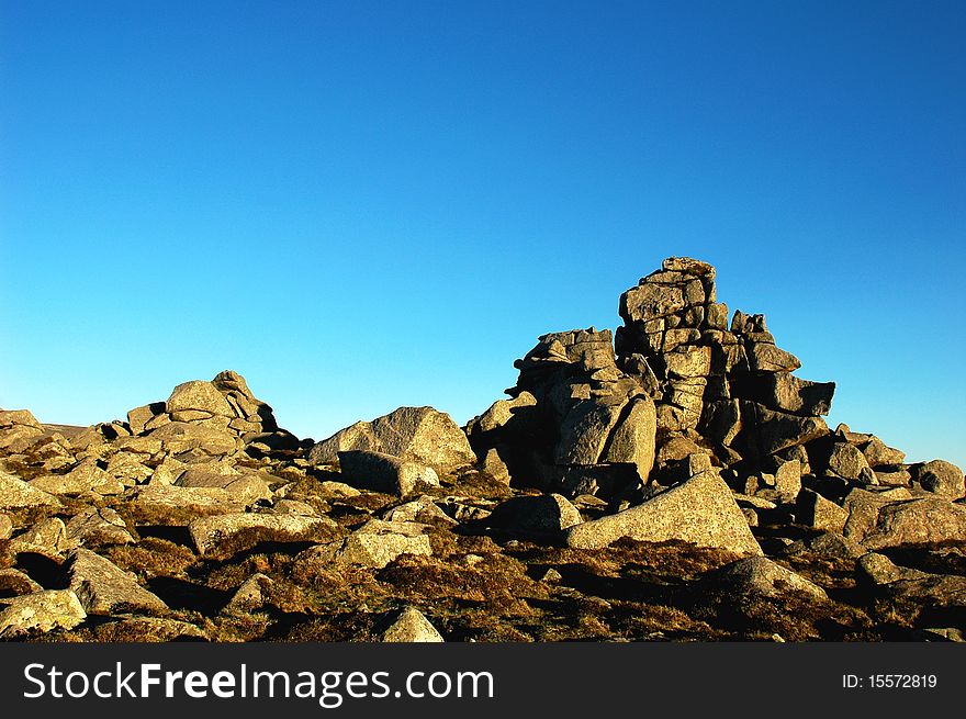 Scenery of huge rocks at the top of mountains with blue skies as backgrounds