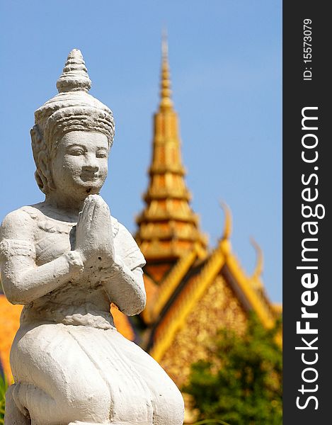 A Stone sculpture of buddha in Phnom Pehn,Cambodia,with the blurred royal palace as background