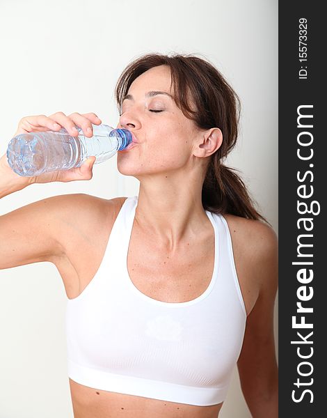 Closeup of woman drinking water after exercising