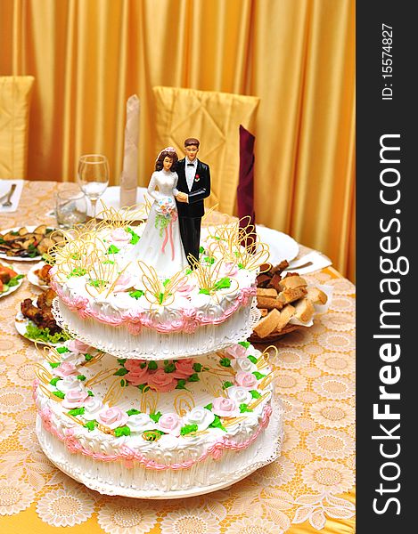 Statues on top of wedding cake on the holiday table