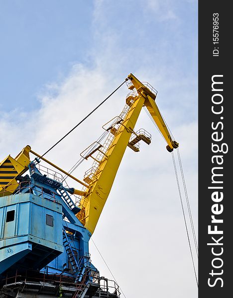 Crane near the mine on the river against blue sky. Crane near the mine on the river against blue sky