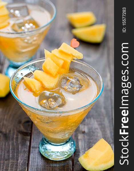 Cocktail with mango fruit on wooden table top. Cocktail with mango fruit on wooden table top