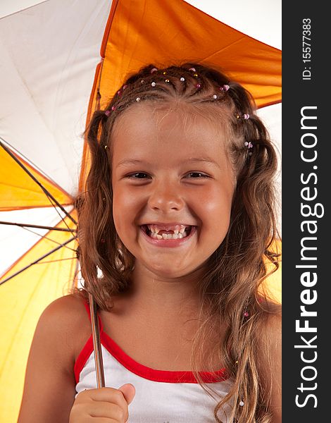 Little girl holding umbrella and showing two missing teeth, studio shot