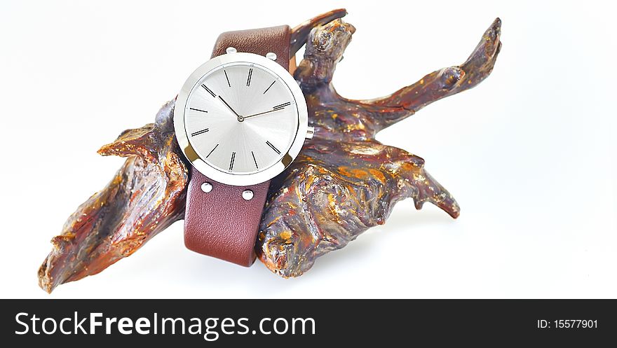 The arm watch with the leather strap on wood in studio