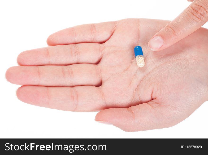 Blue medical capsule in a female hand, isolated