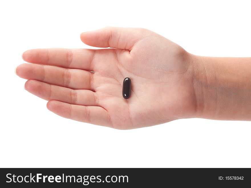 Female hand holding a black capsule, isolated on white