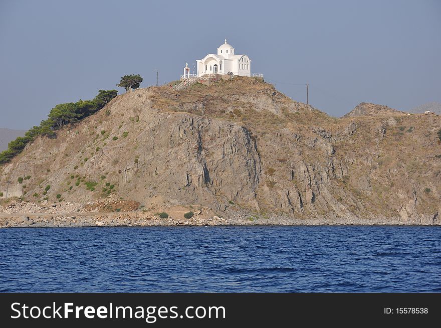 Small white church built on a rocky hill by the sea. Small white church built on a rocky hill by the sea