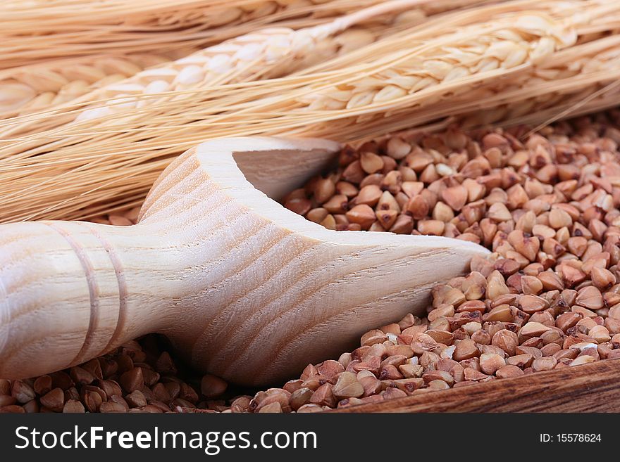 Buckwheat groats with a wooden deep spoon for packaging.