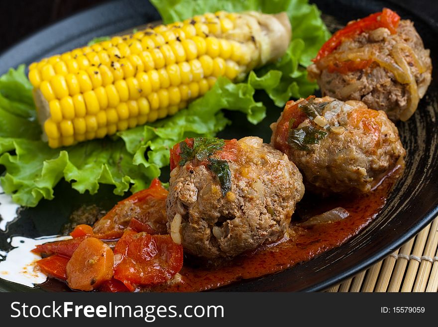 Meetballs served with corn and lettuce. Meetballs served with corn and lettuce