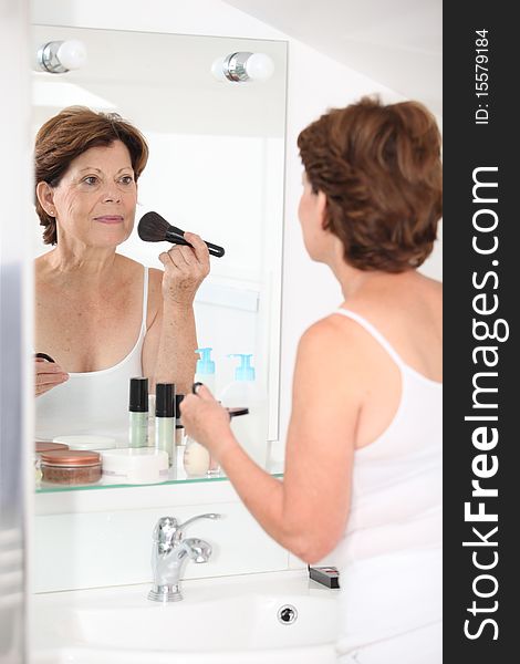 Closeup of senior woman putting makeup on. Closeup of senior woman putting makeup on
