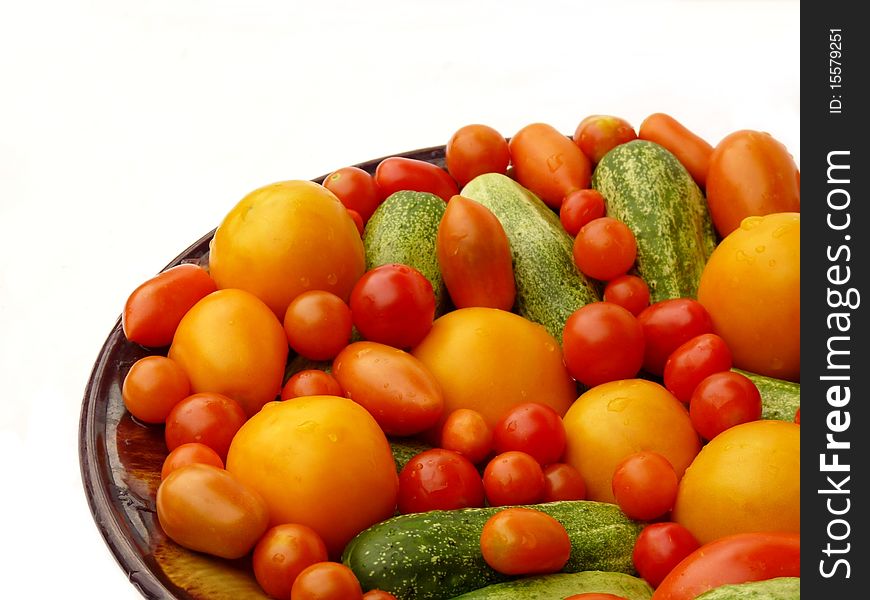Fresh tomatoes and cucumbers on a plate.