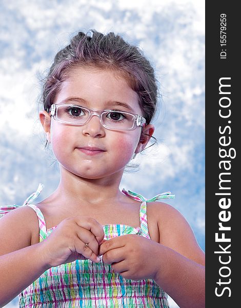 Beautiful little girl unwrapping a candy on studio session