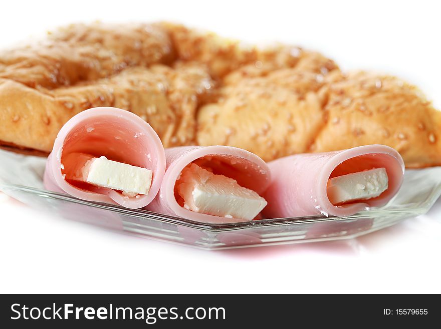 Close-up of closed pizza pastry with garnish of cheese and ham isolated on white