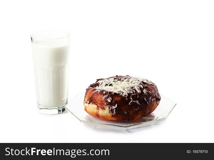 A messy chocolate doughnut and a glass of milk isolated on white. A messy chocolate doughnut and a glass of milk isolated on white