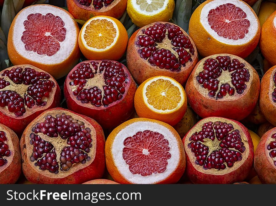 Many opened fruits at a market in Istanbul, Turkey during sunny day. Nice natural background with pomegranates, oranges and grape-fruits