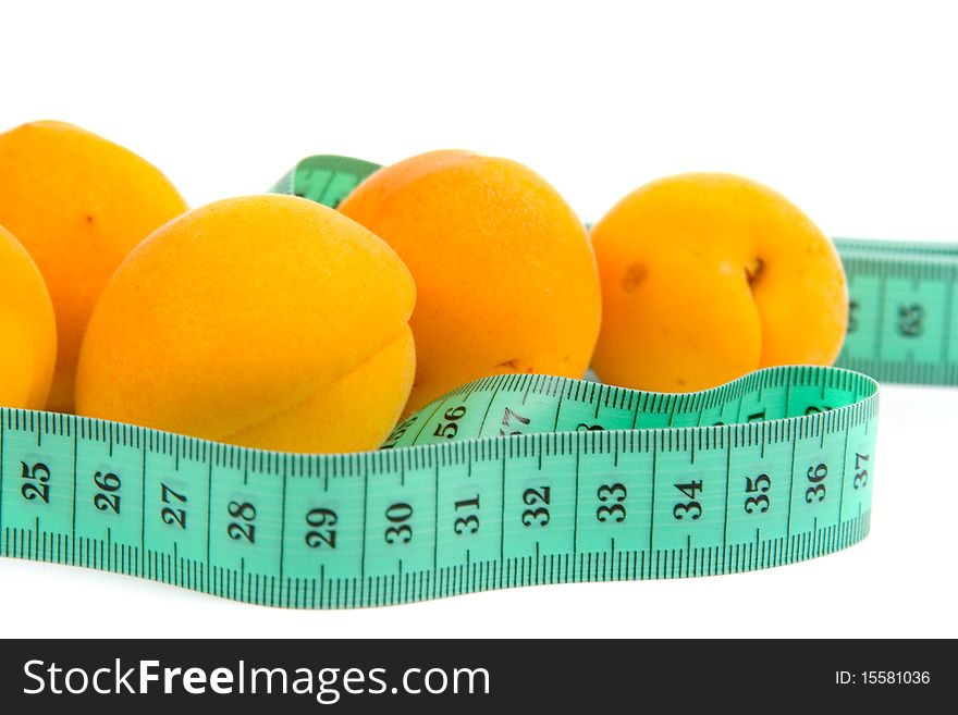Ripe apricots and measuring tape on white background, concept of healthy eating