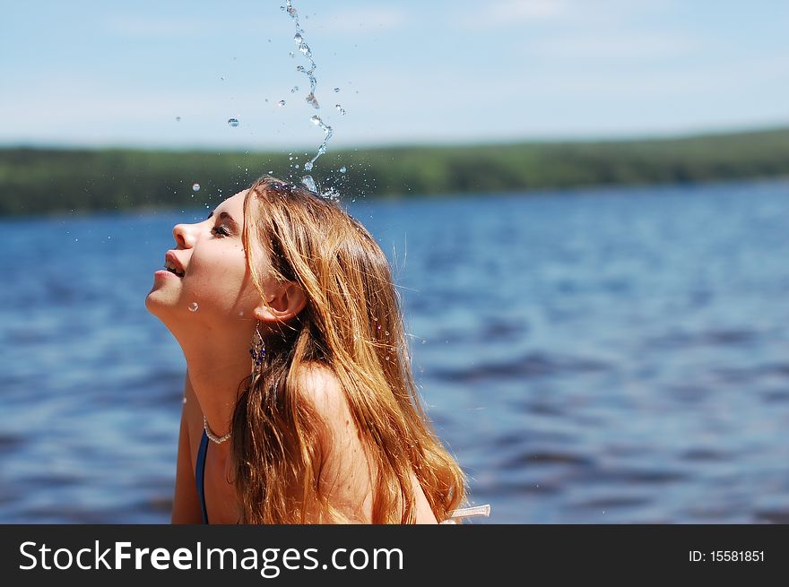 Refreshing water pours a beautiful girl