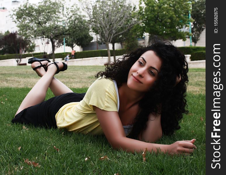 Young happy woman lying on the grass