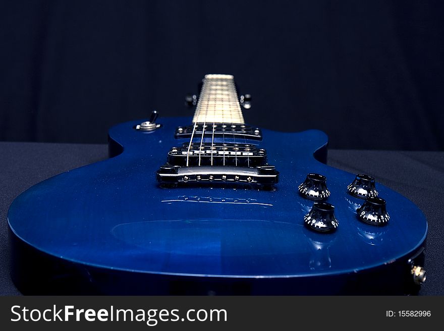 Closeup shot of blue electric guitar from bottom towards top