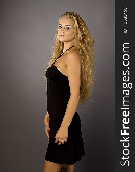 Snapshot woman in a black dress with a gray background with illumination. Snapshot woman in a black dress with a gray background with illumination