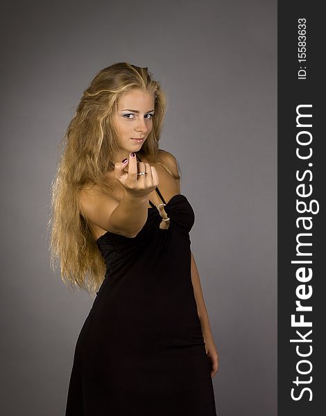 Snapshot woman in a black dress with a gray background with illumination. Snapshot woman in a black dress with a gray background with illumination