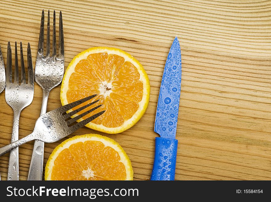 Orange with fork on woood background. Orange with fork on woood background