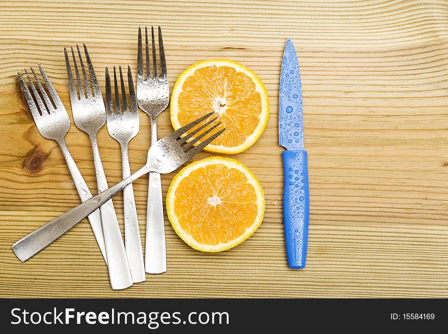 Orange with fork on woood background. Orange with fork on woood background