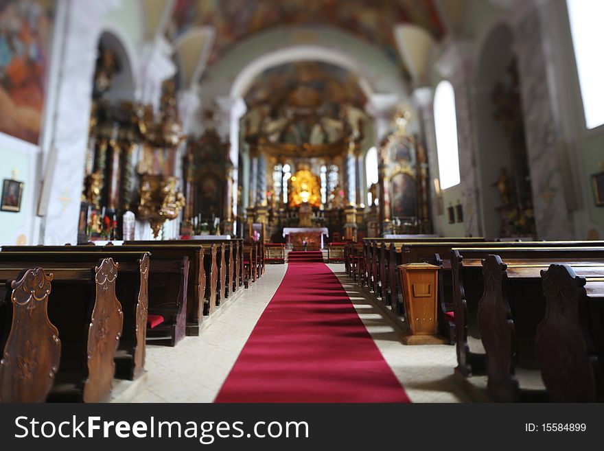 Church interior in Europe with a red carpet leading to the altar.