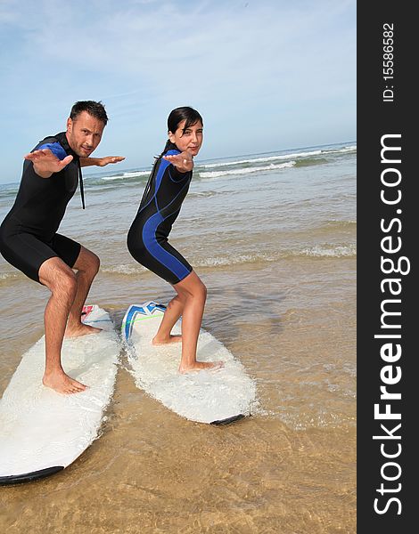 Father and daughter surfing in the ocean. Father and daughter surfing in the ocean