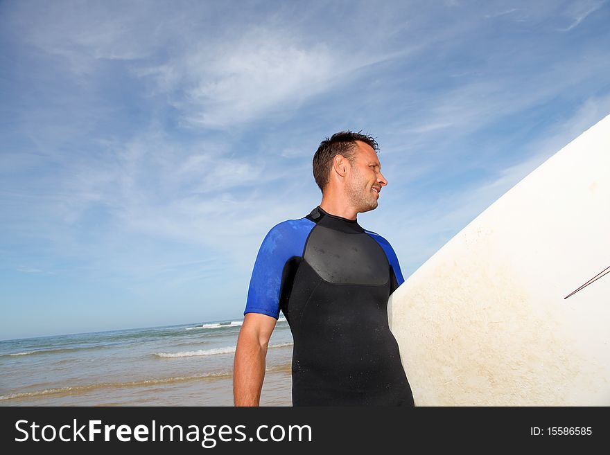 Man standing in water with surfboard. Man standing in water with surfboard
