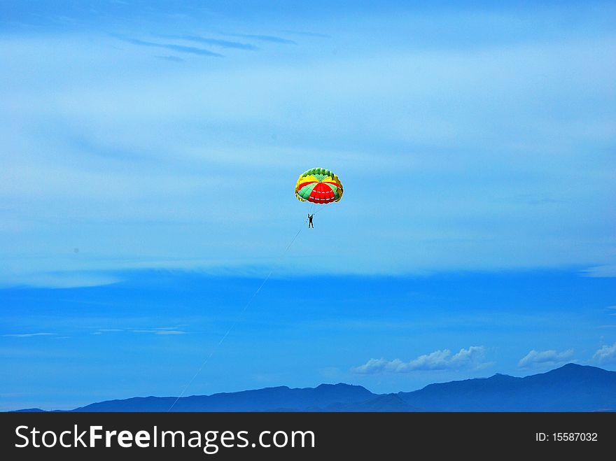 Some people are parasailing over the sea.