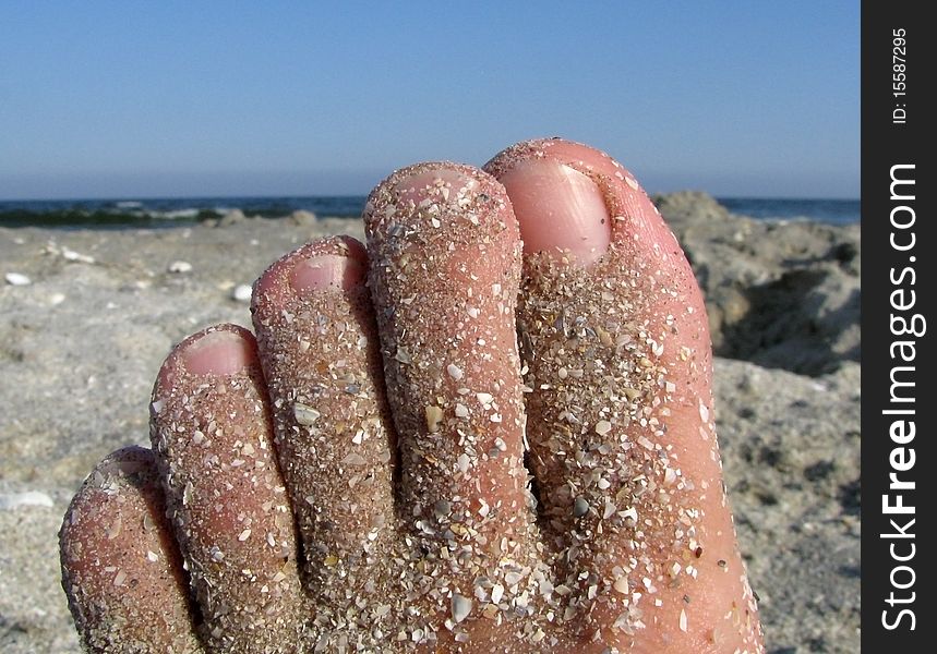 Toes covered by sand at seaside. Summer time, relaxation at the beach. Toes covered by sand at seaside. Summer time, relaxation at the beach.