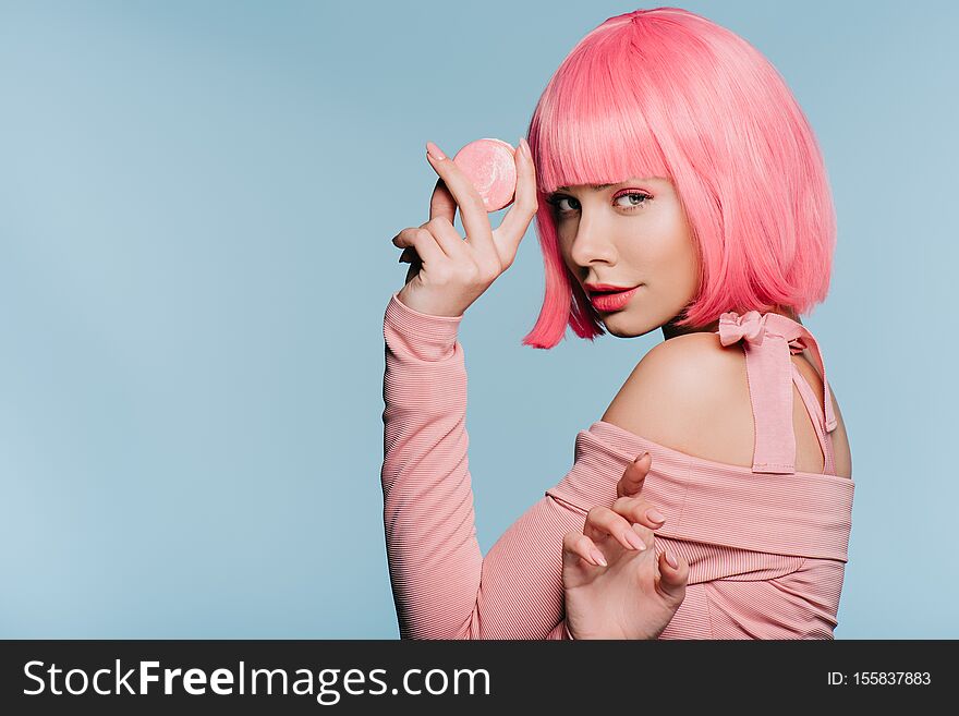 Attractive girl in pink wig posing with sweet macaron isolated