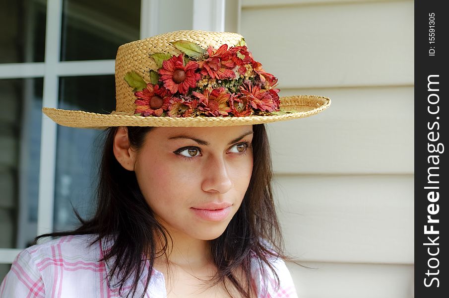 Young woman outdoors wearing a straw hat. Young woman outdoors wearing a straw hat