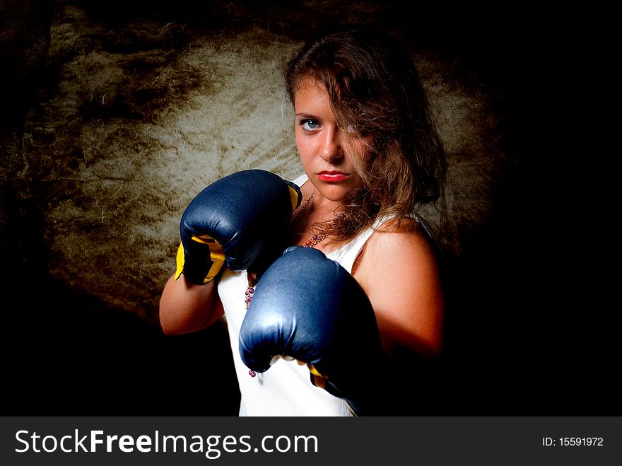 Young aggressive woman in boxing gloves. Young aggressive woman in boxing gloves