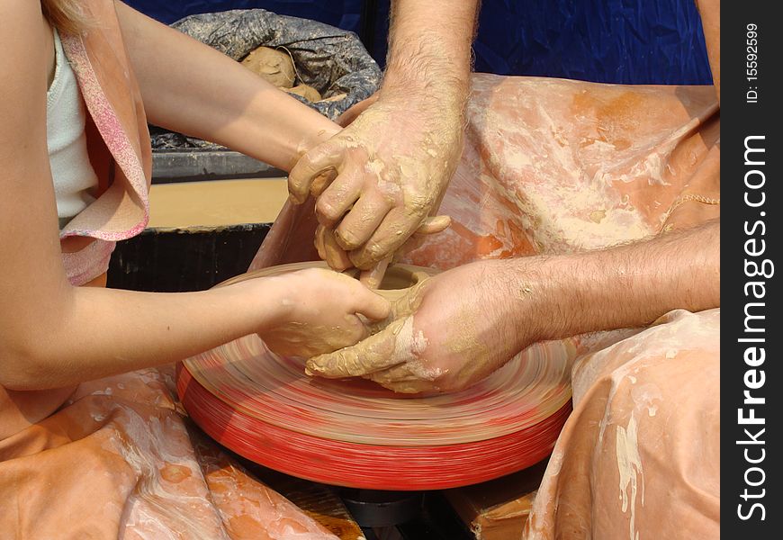Close-up of hands making pottery on a wheel
