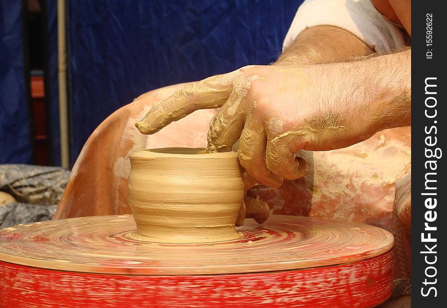 Close-up of hands making pottery on a wheel