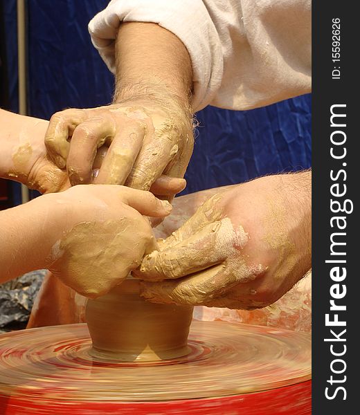 Close-up of hands making pottery on a wheel