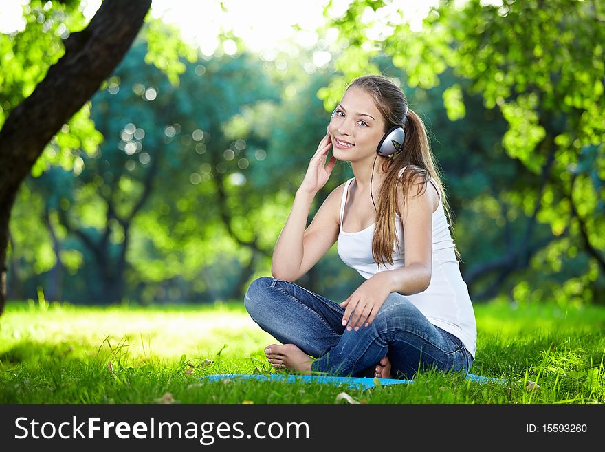 Attractive young girl with headphones in the park. Attractive young girl with headphones in the park