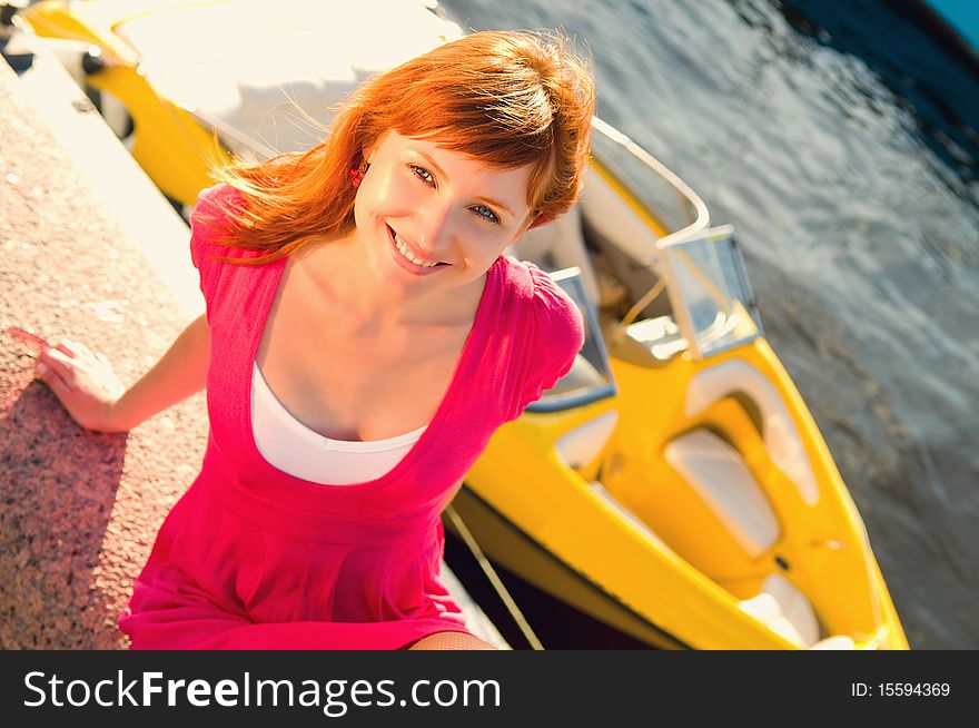 A smiling girl sits on a background of a boat