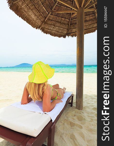 Young woman sunbathing on the chair near the ocean