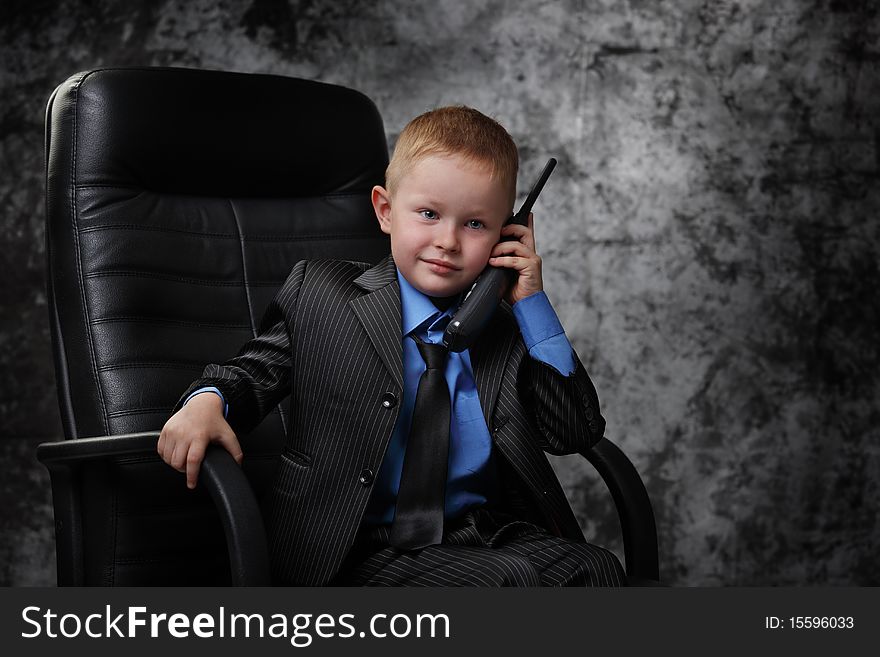The boy in an armchair with phone. The boy in an armchair with phone