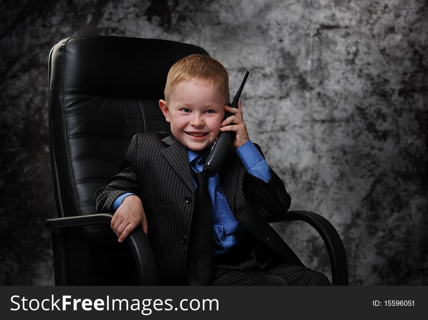 The boy in an armchair with phone. The boy in an armchair with phone