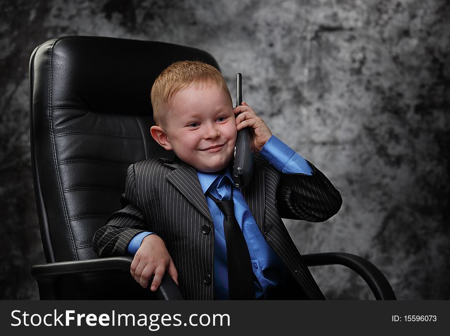 The boy in an armchair with phone. The boy in an armchair with phone
