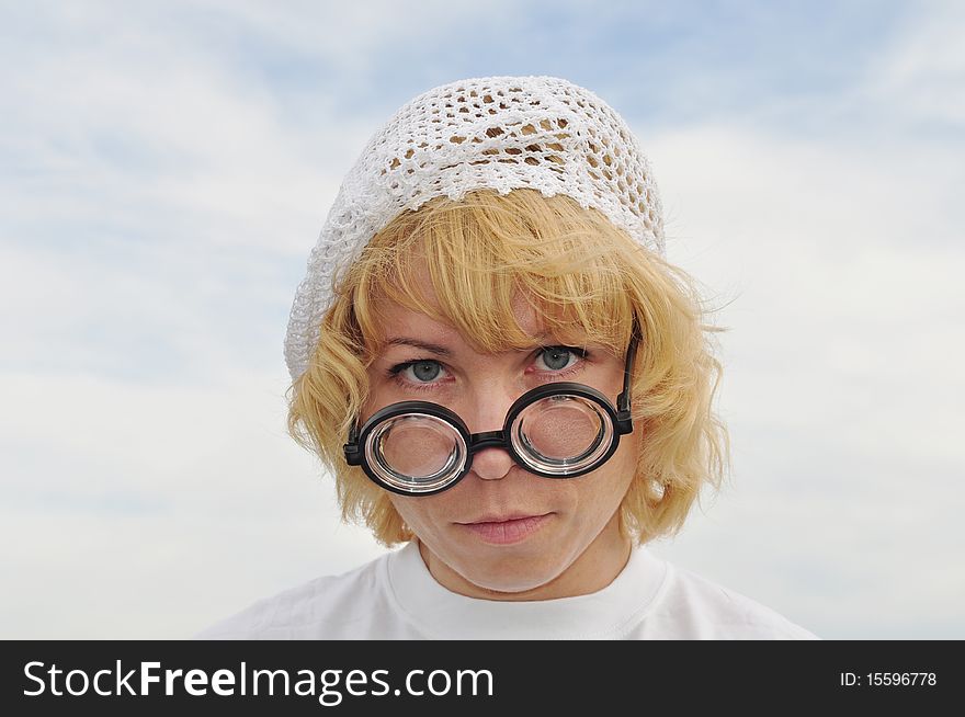 Strong magnifying glasses, a blonde in a white cap, expressive eyes. Strong magnifying glasses, a blonde in a white cap, expressive eyes